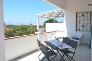 un patio con tavolo e sedie sul balcone. di Venti d'aMare a Marina di Modica