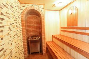 a room with a brick wall and wooden benches at Guest House Gold Oven in Cheboksary