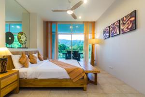 a bedroom with a bed and a large window at The Palm at Veloche Group by Lofty in Karon Beach +61 photos