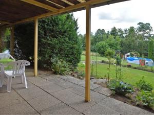 a patio with a table and chairs and a garden at Charming family friendly holiday home with backyard pool in Neukirchen
