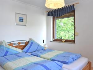 a bedroom with two beds and a window at Charming family friendly holiday home with backyard pool in Neukirchen