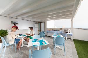 a group of people sitting at tables in a room at B&B Acqua Azzurra in San Vito lo Capo