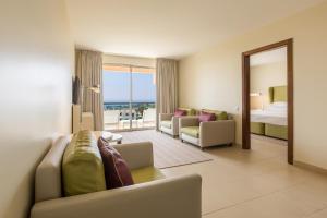 una habitación de hotel con un sofá y una cama en NAU Sao Rafael Suites - All Inclusive, en Albufeira 70 fotos más