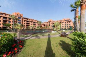 un parque con banco, palmeras y edificios en PUSHE Playa Granada Beach&Golf 1, en Motril