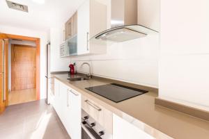Una cocina con gabinetes blancos y un fregadero. en PUSHE Playa Granada Beach&Golf 1, en Motril
