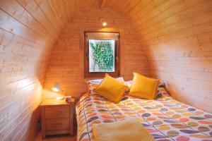 um quarto com uma cama num chalé de madeira em Trecombe Lakes em Falmouth