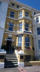 um edifício amarelo com escadas em frente em 17 Wilmington Square em Eastbourne