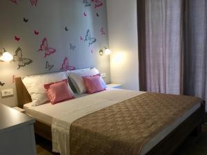 a bedroom with a bed with butterflies on the wall at Apartments Lozina in Drvenik