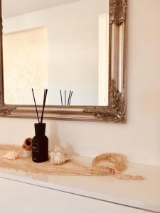 um espelho e um vaso numa prateleira num quarto em Apartments Lozina em Drvenik