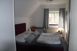 ein Schlafzimmer mit 2 Betten und einem Hund auf dem Bett in der Unterkunft Pension Nordwind in Hedwigenkoog