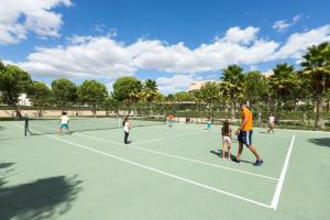 a group of people playing tennis on a tennis court at NAU Sao Rafael Suites - All Inclusive in Albufeira