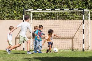 a group of children playing with a soccer ball at NAU Sao Rafael Suites - All Inclusive in Albufeira