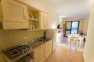 een keuken met een wastafel en een fornuis top oven bij Appartamenti Sole di Sardegna in Cala Liberotto
