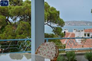 a balcony with a chair and a view of the water at Mavi Pension in Ayvalık