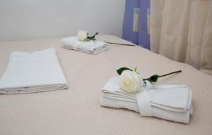 a bed with towels and flowers on top of it at Sweet Room Old Town Split in Split