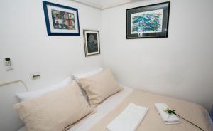- une chambre avec un lit doté de deux oreillers et de photos sur le mur dans l'établissement Sweet Room Old Town Split, à Split