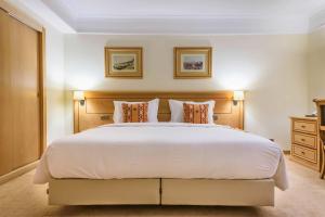 a bedroom with a large white bed with two pillows at Hotel Real Palacio in Lisbon