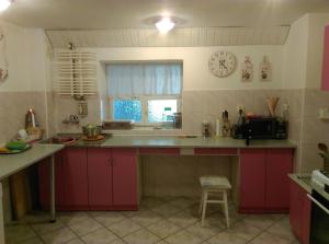 a kitchen with red cabinets and a clock on the wall at Cichy Zakątek in Sianozety