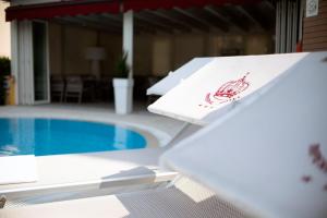 un tavolo con un cartello di aragosta accanto alla piscina di Hotel Imperial ***S a Garda
