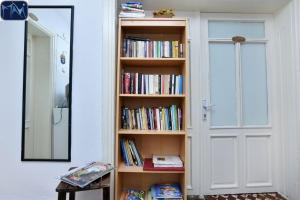 un estante lleno de libros junto a una puerta en Mavi Pension, en Ayvalık