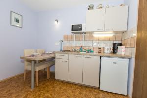a kitchen with white cabinets and a table and a sink at Apartment Ina in Bled