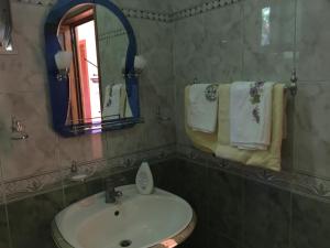 a bathroom with a sink and a mirror and towels at Sara Guesthouse in Berat