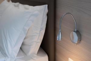 uma cama com uma almofada e um rato na parede em Hotel Imperial ***S em Garda