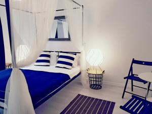 1 dormitorio con cama con dosel y almohadas azules y blancas en Argö Costinești, en Costinesti