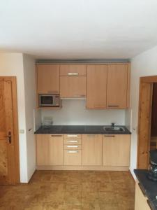 a kitchen with wooden cabinets and a sink at Haus Johannes in Wagrain