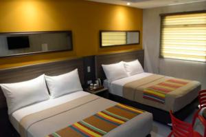 a hotel room with two beds and a tv at Express Inn Cebu Osmena in Cebu City