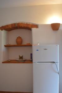 kuchnia z białą lodówką i półką w obiekcie Casa Sarticola w mieście Castelnuovo Magra