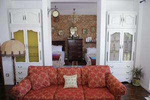 salon z czerwoną kanapą i ceglaną ścianą w obiekcie Apartment Nesti in Pristina Kosovo w Prisztinie