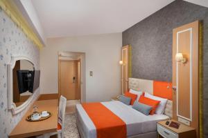 a hotel room with a bed and a desk and a television at Golden Orange Hotel in Antalya