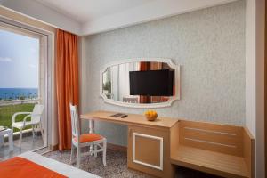 a bedroom with a desk and a mirror and a bed at Golden Orange Hotel in Antalya