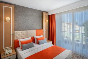 a bedroom with a bed and a large window at Golden Orange Hotel in Antalya