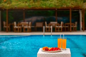 a plate of fruit on a table next to a pool at Golden Orange Hotel in Antalya