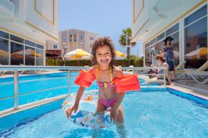 a young girl in a pool on an inflatable at Golden Orange Hotel in Antalya