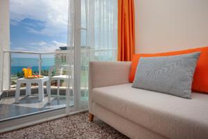 a living room with a couch and a large window at Golden Orange Hotel in Antalya