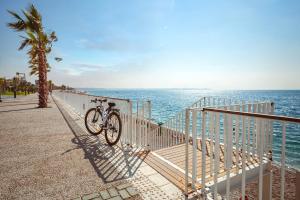 a bike parked on a fence near the ocean at Golden Orange Hotel in Antalya