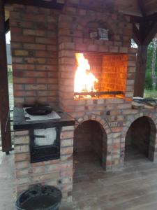 a brick oven with a fire inside of it at Шале Озера in Melʼniki