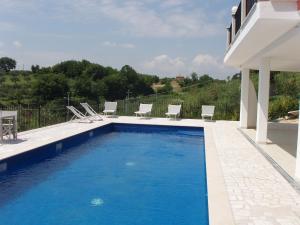 basen z krzesłami i dom w obiekcie Residence Candeloro w mieście Francavilla al Mare