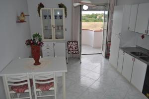 una cucina con tavolo, sedie e finestra di La casetta di Amélie a Agrigento