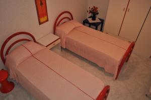 una camera con due letti e un tavolo con fiori di La casetta di Amélie a Agrigento