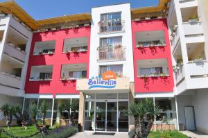 陽光海灘的住宿－Hotel BelleVille，一座红色的大建筑,上面有标志