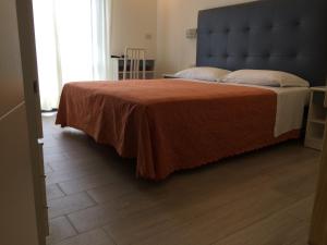 una camera da letto con un grande letto con una coperta marrone di Hotel Pigalle a Riccione