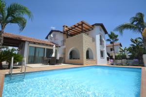 une villa avec une piscine en face d'une maison dans l'établissement Narcissos Villa Thekla, à Ayia Napa