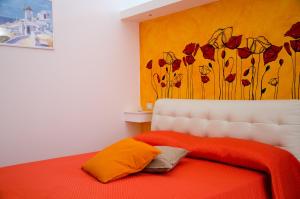 1 dormitorio con 1 cama con una pintura floral en la pared en Le Stagioni, en Massafra