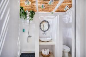 a white bathroom with a sink and a mirror at Sol Mare Salis in Kamari +58 photos