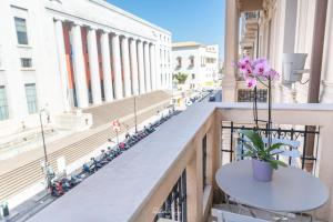 un balcone con tavolo e fiori su un edificio di Via Roma 315 Bed and Breakfast a Palermo