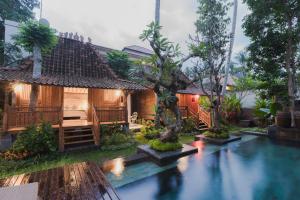 ein Haus mit einem Swimmingpool davor in der Unterkunft Kakul Heritage Villas in Ubud